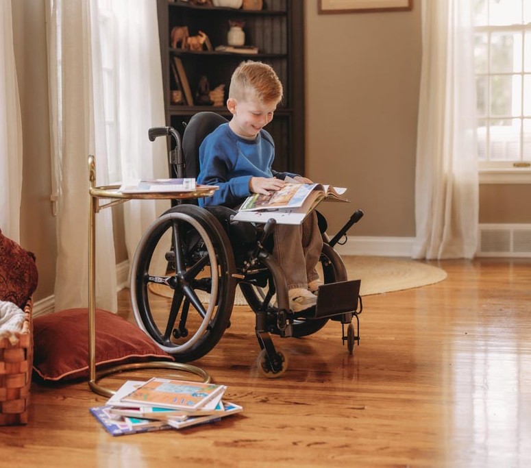 boy in wheelchair reading book